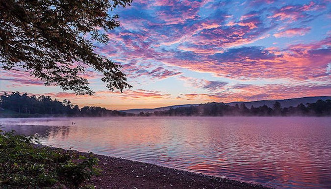 A pink sunset over Ethel Springs Lake with mist on the water
